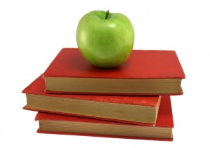 green apple on stack of 3 red books